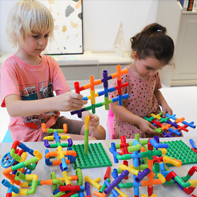 enfants jouant aux jeux de construction tubes emboitables