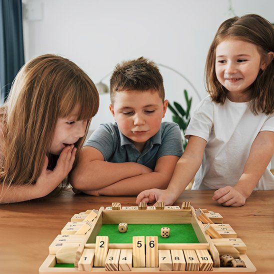 Trois enfant parents jouant Jeux de société en bois 